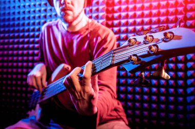 Bas gitar ses kayıt Studio oynayan genç adam. Modern arka plan