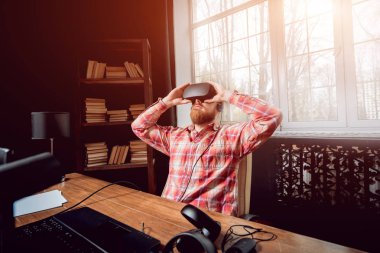 Sanal gerçeklik giyen genç sakallı adam ofiste gözlükler