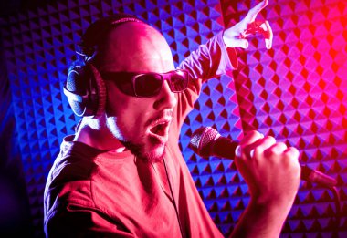 Kayıt stüdyosu olarak bir mikrofon ile şarkıcı söylüyor. Modern arka plan