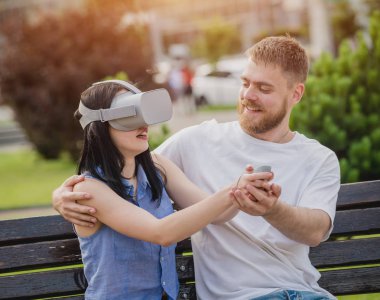 Genç çift sanal gerçeklik gözlükle sokakta bir oyun oynuyor. VR kulaklık.