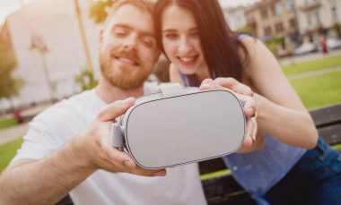 Genç çift sanal gerçeklik gözlükle sokakta bir oyun oynuyor. VR kulaklık.