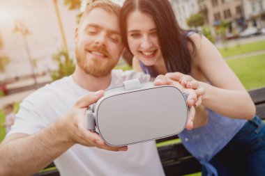 Genç çift sanal gerçeklik gözlükle sokakta bir oyun oynuyor. VR kulaklık.