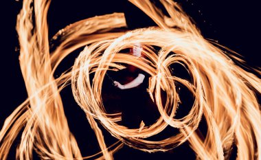 Gösteri yangın. Karanlıkta ateş performans gösteren genç adam.