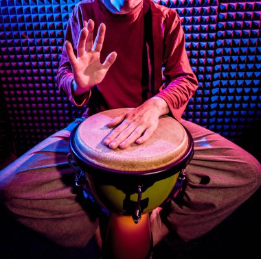 Genç adam djembe ses kayıt stüdyosu içinde oynamaya. Afrika davul