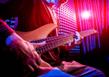Bas gitar ses kayıt Studio oynayan genç adam. Modern arka plan