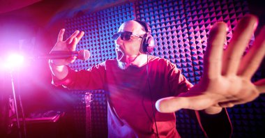 Kayıt stüdyosu olarak bir mikrofon ile şarkıcı söylüyor. Modern arka plan