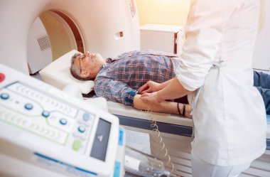 Doktor ve hasta hastanede bilgisayarlı tomografi odasında. Tıbbi donatımı.