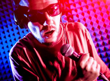 Kayıt stüdyosu olarak bir mikrofon ile şarkıcı söylüyor. Modern arka plan