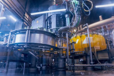 Otomatik Dolum Makinası su Plastik Pet şişe dökülen. Bira üretim. Endüstriyel arka plan.