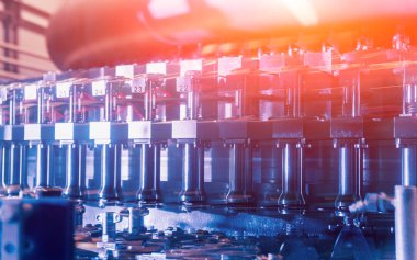 Otomatik Dolum Makinası su Plastik Pet şişe dökülen. Bira üretim. Endüstriyel arka plan.