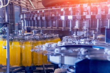 Otomatik Dolum Makinası su Plastik Pet şişe dökülen. Bira üretim. Endüstriyel arka plan.