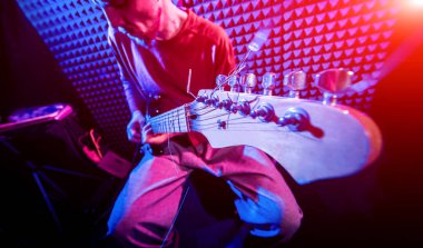 Genç adam gitar ses kayıt stüdyosu içinde oynamaya. Modern arka plan