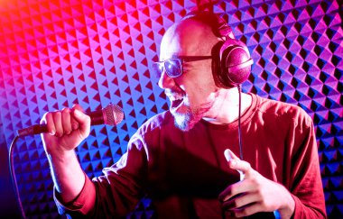 Kayıt stüdyosu olarak bir mikrofon ile şarkıcı söylüyor. Modern arka plan