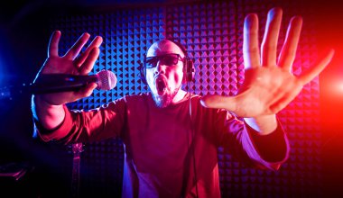 Kayıt stüdyosu olarak bir mikrofon ile şarkıcı söylüyor. Modern arka plan