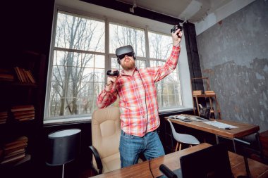 Sanal gerçeklik giyen genç sakallı adam ofiste gözlükler