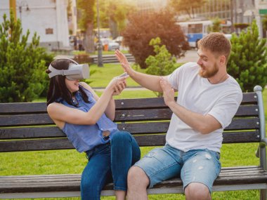 Genç çift sanal gerçeklik gözlükle sokakta bir oyun oynuyor. VR kulaklık.