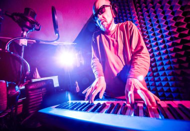 Ses kayıt stüdyosunda piyano genç adam. Modern arka plan