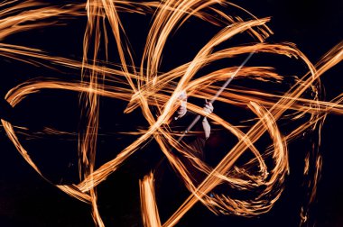 Gösteri yangın. Karanlıkta ateş performans gösteren genç adam.