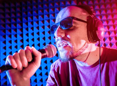 Kayıt stüdyosu olarak bir mikrofon ile şarkıcı söylüyor. Modern arka plan