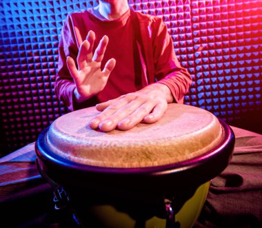 Genç adam djembe ses kayıt stüdyosu içinde oynamaya. Afrika davul
