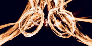 Gösteri yangın. Karanlıkta ateş performans gösteren genç adam.