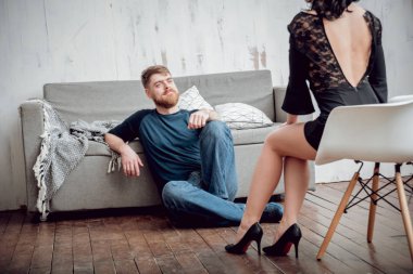 Katta oturan genç bir adam bir genç seksi kıza bakar.