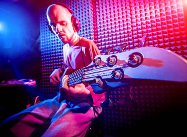 Bas gitar ses kayıt Studio oynayan genç adam. Modern arka plan