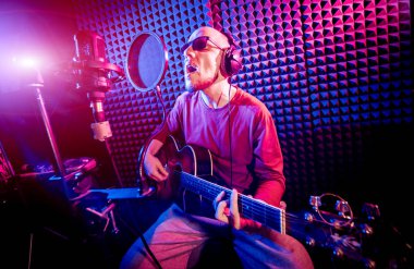 Bir mikrofon ve kayıt stüdyosu gitar çalmak ile şarkıcı söylüyor. Modern arka plan