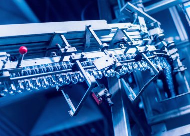 Otomatik Dolum Makinası su Plastik Pet şişe dökülen. Bira üretim. Endüstriyel arka plan.