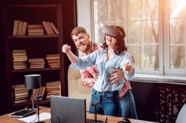 Genç adam ve kız çalış bir oyun sanal gerçeklik gözlükleri ile dolap odası. 