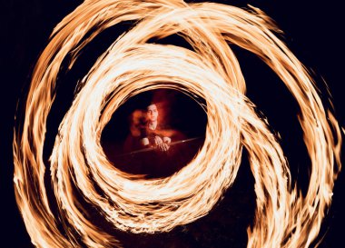 Gösteri yangın. Karanlıkta ateş performans gösteren genç adam.