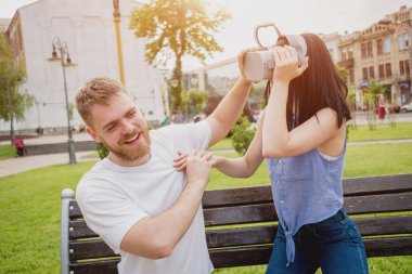 Genç çift sanal gerçeklik gözlükle sokakta bir oyun oynuyor. VR kulaklık.