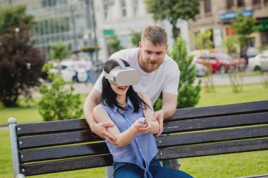 Genç çift sanal gerçeklik gözlükle sokakta bir oyun oynuyor. VR kulaklık.
