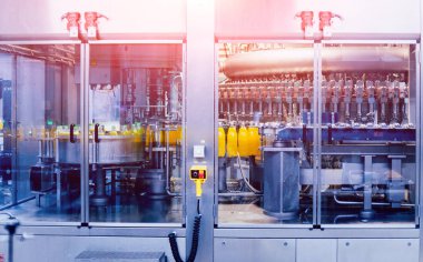 Otomatik Dolum Makinası su Plastik Pet şişe dökülen. Bira üretim. Endüstriyel arka plan.