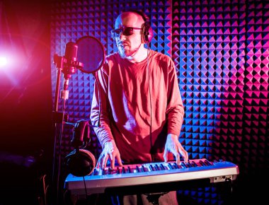 Ses kayıt stüdyosunda piyano genç adam. Modern arka plan