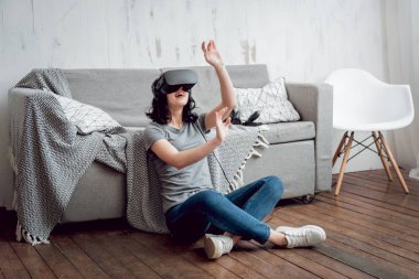 Cam kenarında oturan genç kız sanal gerçeklik giyiyor koruyucu gözlük