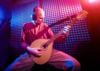 Buzuki ses kayıt stüdyosu olarak oynamaya bir genç adam. Modern arka plan