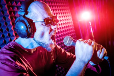 Kayıt stüdyosu olarak bir mikrofon ile şarkıcı söylüyor. Modern arka plan