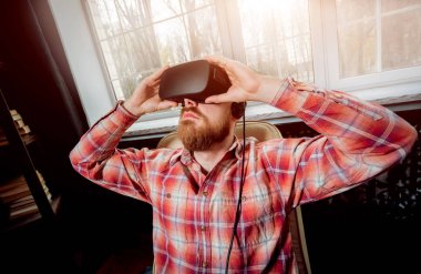 Sanal gerçeklik giyen genç sakallı adam ofiste gözlükler