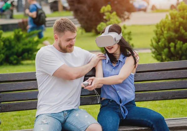 Genç çift sanal gerçeklik gözlükle sokakta bir oyun oynuyor. VR kulaklık.