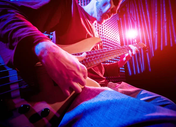 Bas gitar ses kayıt Studio oynayan genç adam. Modern arka plan