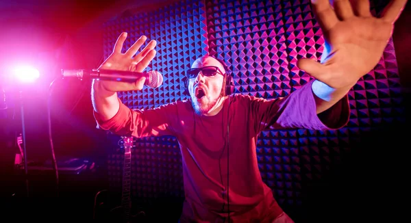 Kayıt stüdyosu olarak bir mikrofon ile şarkıcı söylüyor. Modern arka plan