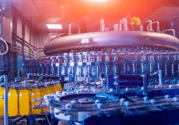 Otomatik Dolum Makinası su Plastik Pet şişe dökülen. Bira üretim. Endüstriyel arka plan.