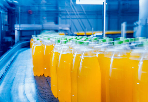 Beverage factory interior. Conveyor with bottles for juice or water. Modern equipments