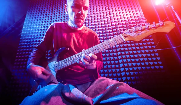 Genç adam gitar ses kayıt stüdyosu içinde oynamaya. Modern arka plan