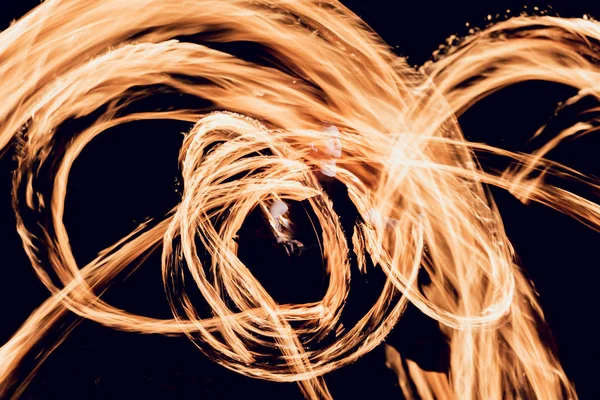 Gösteri yangın. Karanlıkta ateş performans gösteren genç adam.