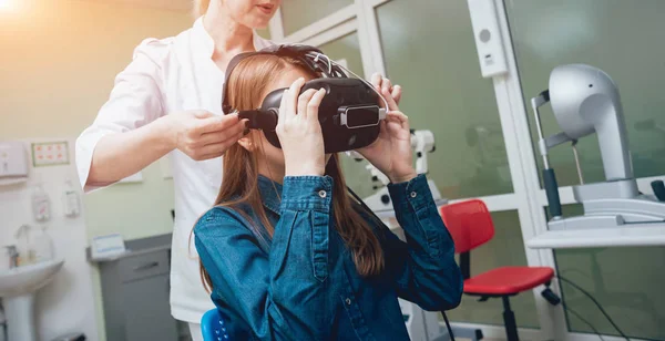 Okulistyka Lekarza Sprawdzanie Wizji Dziewczyna Pomocą Wirtualnej Rzeczywistości Gogle — Zdjęcie stockowe