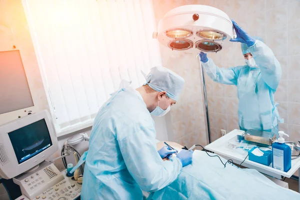 外科医生和助理在手术室用手术设备 — 图库照片