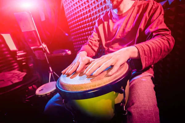 Genç adam djembe ses kayıt stüdyosu içinde oynamaya. Afrika davul