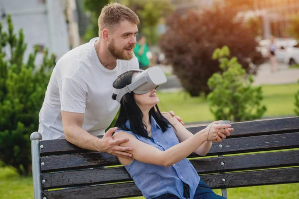 Genç çift sanal gerçeklik gözlükle sokakta bir oyun oynuyor. VR kulaklık.